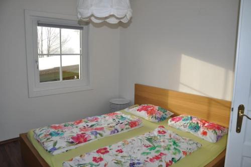 two beds in a bedroom with a window at Ferienwohnung, wenige Minuten vom Wörthersee in Schiefling am See