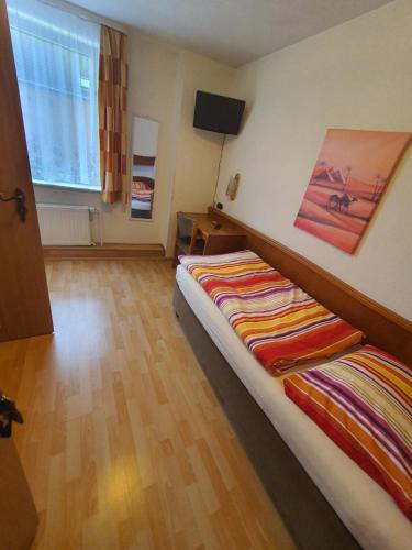 a bedroom with a bed and a tv on a wall at Hotel Busch in Wilster in Wilster