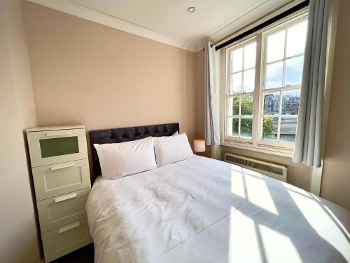 ロンドンにある2 Bedroom Apartment in Westminsterのベッドルーム(白いベッド1台、窓付)