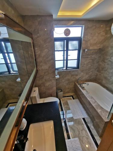 a bathroom with a tub and a toilet and a sink at R&F PRINCESS COVE at ANJU in Johor Bahru