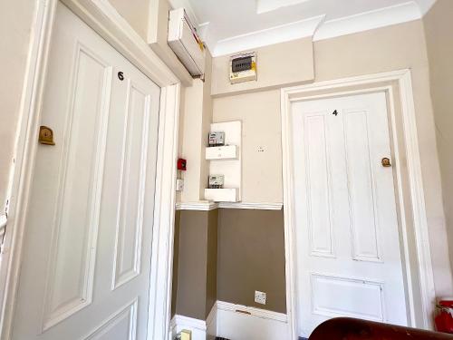 ロンドンにある2 Bedroom Apartment in Westminsterの白い扉と棚のある廊下