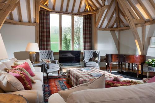 a living room with couches and a piano at Lower Farm Barn in Hungerford