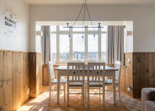 a dining room with a table and chairs and a window at West Bay in Middelkerke