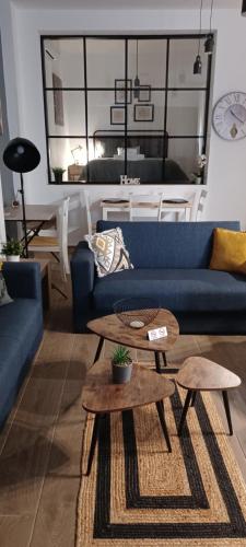 un soggiorno con divano blu e 2 tavoli di HOME Sweet HOME a Mytilini