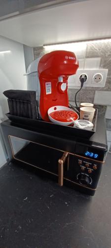 a red mixer sitting on top of a microwave at Petite suite with backyard. in Mytilini