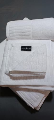 a stack of white towels sitting on a table at Petite suite with backyard. in Mytilini