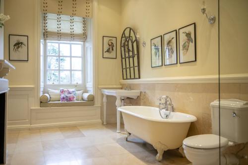 a bathroom with a tub and a toilet and a sink at Eslington East Wing in Alnwick