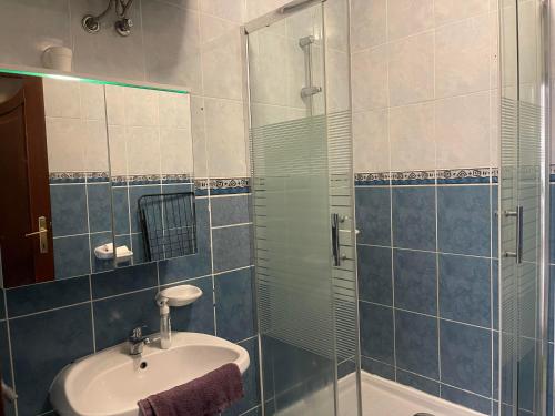 La salle de bains est pourvue d'un lavabo et d'une douche en verre. dans l'établissement Liliána Apartman Siófok, à Siófok
