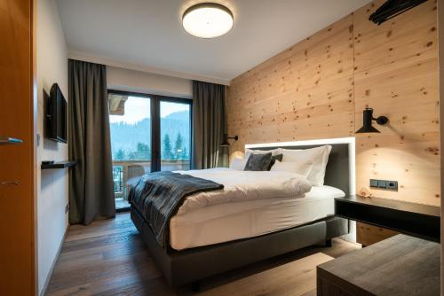 a bedroom with a bed with a wooden wall at KaiserMoments in Going