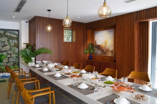 a dining room with a long table with food on it at Trần Phú Villa Sea View in Vung Tau