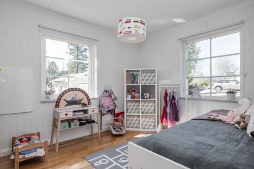 1 dormitorio con 1 cama, escritorio y ventanas en Spacious accommodation near Stockholm with heated pool, 
