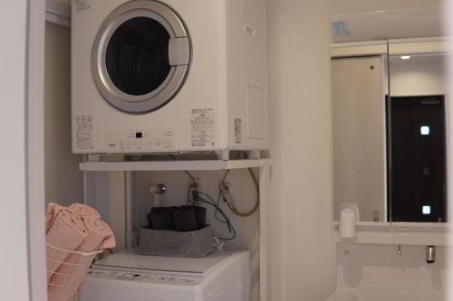 a laundry room with a washing machine and a microwave at きくのこ3缶ヴィラ＆テラス　 in Miyako Island