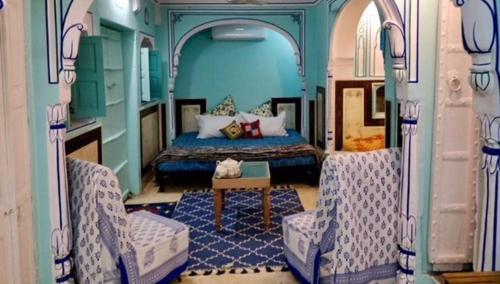 a train room with a bed and two chairs at Jaipur Haveli in Jaipur