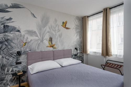 a bedroom with a bed with birds on the wall at Pappagallo Apartments in Vienna