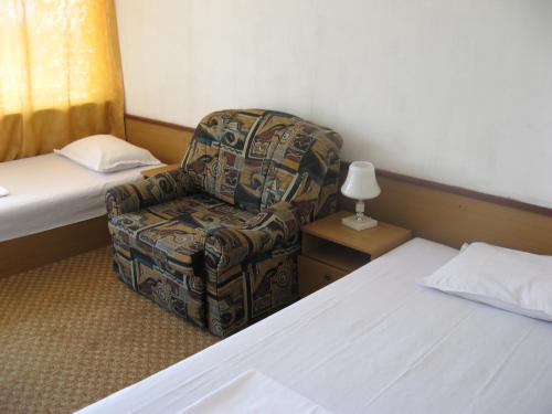 a room with a bed and a chair and a bed at Hotel Zora in Kranevo