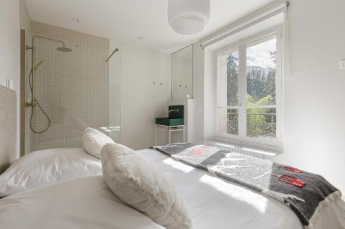 Habitación blanca con cama y ventana en La Savoy 2 - Thermes de Saint-Gervais - Happy Rentals en Saint-Gervais-les-Bains