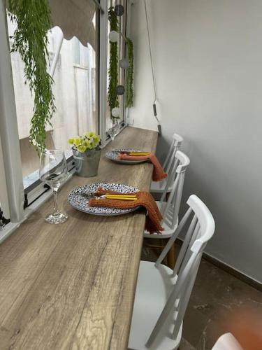 a wooden table with two plates of food and a glass at Jelinas bright apartment in the centre of Nafplio in Nafplio