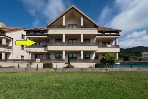a building with a yellow arrow on the side of it at Apartamento Ancora Caldebarcos in San Mamede de Carnota