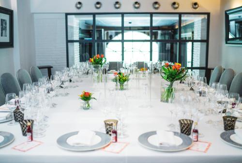 a long white table with vases and flowers on it at Hotel Lungarno - Lungarno Collection in Florence