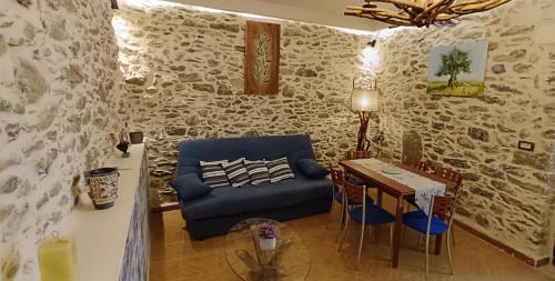 uma sala de estar com um sofá azul e uma mesa em VILLA PENELOPE em Tourlotí