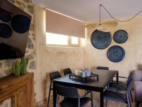 a dining room with a table and blue plates on the wall at Vrachos Suites Mykonos in Mýkonos City
