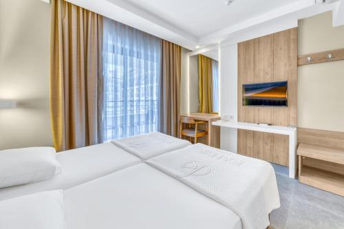 a hotel room with a white bed and a desk at Kahya Hotel in Alanya