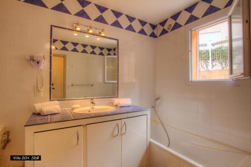 a bathroom with a sink and a mirror and a tub at Résidence de Tourisme Mare e Macchia in Tizzano