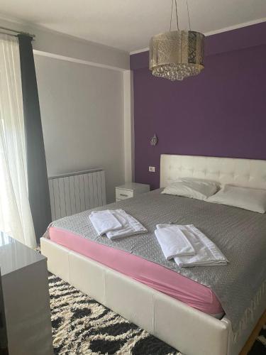 1 dormitorio con 1 cama grande y paredes moradas en Viki Apartments, en Strumica
