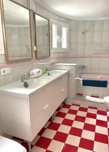 a bathroom with a sink and a red and white checkered floor at Villa Silvia LOCDENIA in Denia