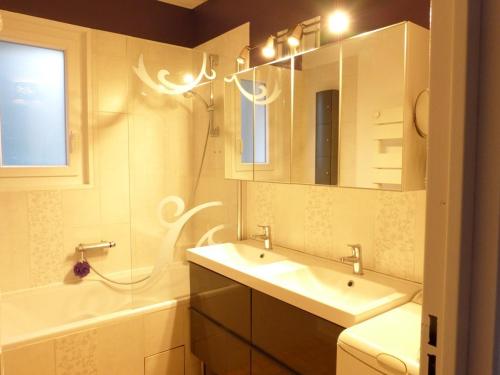 uma casa de banho com um lavatório, um espelho e uma banheira em gîtes de Calistane em Saint-Vincent-de-Mercuze