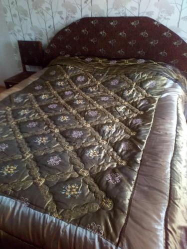 a bed with a quilt on it in a bedroom at DONNA in Tsinsopʼeli