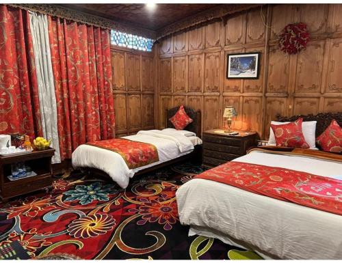 two beds in a room with wooden walls at House Boat Shahnama, Dal Lake in Kārapur