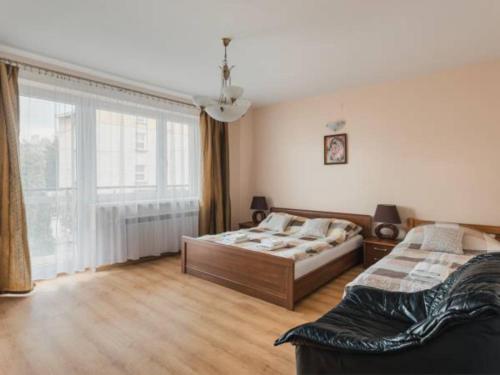 1 dormitorio con 2 camas y ventana grande en Noclegi Wadowice, en Wadowice