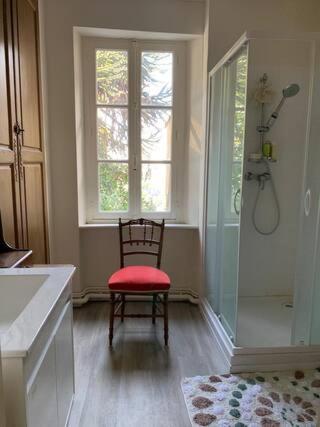 une salle de bain avec une chaise avec une fenêtre et une douche dans l'établissement La Miséricorde, à Coutances