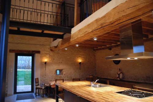 - une cuisine avec un comptoir et une cuisinière four supérieur dans l'établissement La Muzardière aux Gîtes de Cormenin, à Saint-Hilaire-sur-Puiseaux