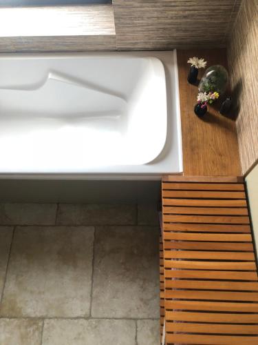 La salle de bains est pourvue d'un lavabo blanc et de parquet. dans l'établissement La Muzardière aux Gîtes de Cormenin, à Saint-Hilaire-sur-Puiseaux