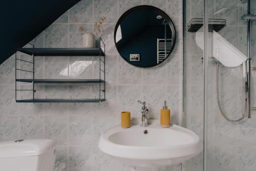 La salle de bains est pourvue d'un lavabo, d'un miroir et de toilettes. dans l'établissement Dzikosc Orlowiec, à Lądek-Zdrój