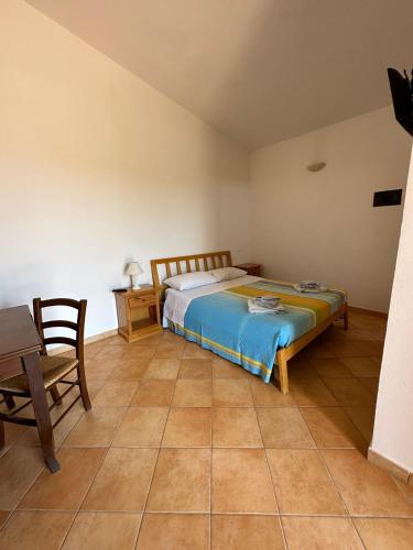 a bedroom with a bed and a table and a chair at Appartamenti Delfino in Lampedusa
