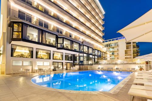 un gran edificio con una gran piscina en Hotel Sporting en Rímini