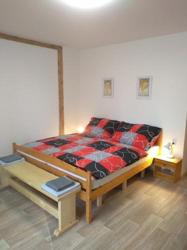 - une chambre avec un lit doté d'une couette rouge et noire dans l'établissement Hrnčírna, à Kněževes