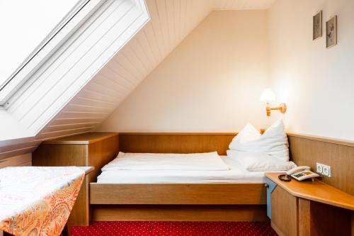 a small bedroom with a bed and a window at PANORAMA SportHOTEL in Wenigzell