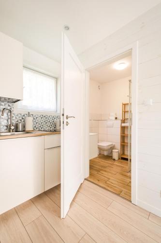 a kitchen with a door open to a bathroom at Apartamenty Tęsknoty 10 in Dziwnów