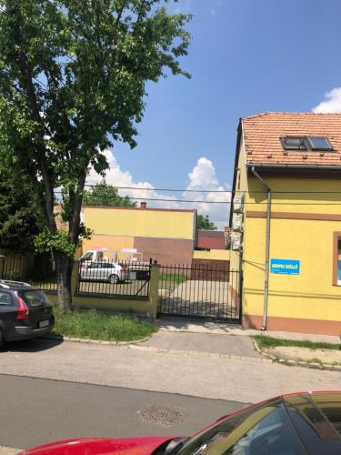 ブダペストにあるKonvoj szállóの通りの隣の柵のある黄色い建物