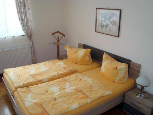 1 Schlafzimmer mit 2 Betten und gelber Bettwäsche in der Unterkunft Wachholz, Ferienwohnung in Celle