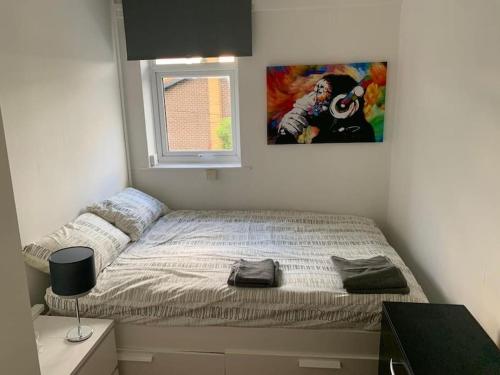 a bedroom with a bed with a picture on the wall at Cozy Room near City Centre in Manchester