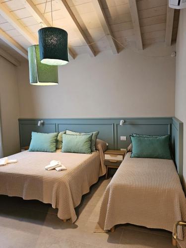 two beds sitting next to each other in a room at Padre Relais di Campagna in Collemezzano