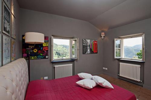 a bedroom with a red bed with two pillows on it at Villa Margherita appartamento per 5 in Villa ottocentesca in Castiglione Chiavarese