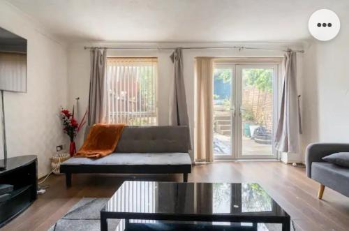ein Wohnzimmer mit einem Sofa und einem Tisch in der Unterkunft Home in Medway 3bedroom free sports channel, parking in Chatham