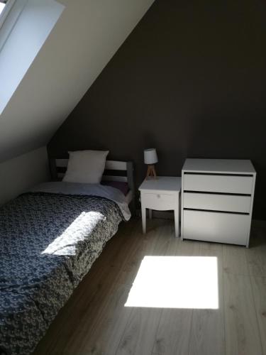 une chambre avec un lit, une commode et une fenêtre dans l'établissement Kerguil-hanna agréable et familiale, 4 pers, piscine privée du 15 juin à mi-septembre, à Moëlan-sur-Mer