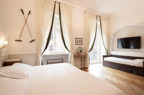 a bedroom with two beds and a flat screen tv at Relais Donna Lucrezia in Rome